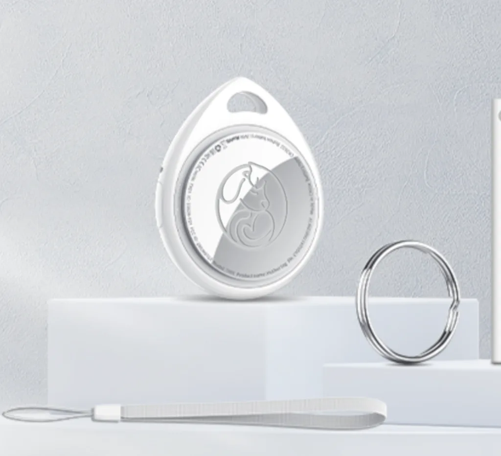 Rastreador NexZoo blanco en forma de gota con el logo grabado, junto a una argolla metálica y una correa
