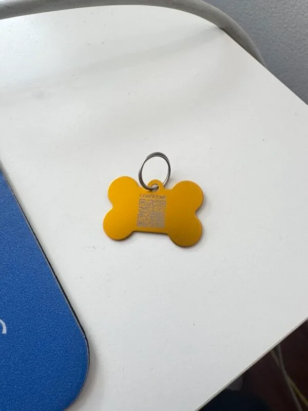 Placa forma hueso dorada NexZoo con codigo QR — placa identificacion mascota Colombia